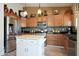 Well-lit kitchen with stainless steel appliances, granite countertops, and a white center island at 30248 W Earll Dr, Buckeye, AZ 85396