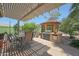 Inviting outdoor kitchen with a built-in grill, shaded seating, and lush landscaping at 30248 W Earll Dr, Buckeye, AZ 85396