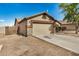 Side view of single-story home featuring a two-car garage with stone accents and tidy landscaping at 3029 N 83Rd Ln, Phoenix, AZ 85037