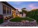 Landscaped backyard with artificial turf, stone accents, a seating area, and lovely outdoor lighting at 3437 E Appaloosa Rd, Gilbert, AZ 85296