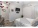 Well-lit bedroom with wood-look floors, white doors, and a flat-screen television mounted to the wall at 3437 E Appaloosa Rd, Gilbert, AZ 85296