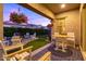 Charming covered patio with ample seating, a firepit, and a manicured lawn with floral arrangements at 3437 E Appaloosa Rd, Gilbert, AZ 85296