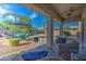 Relaxing outdoor patio with comfortable seating, ceiling fan, and views of the lush backyard and sparkling pool area at 3736 E Cotton Ct, Gilbert, AZ 85234