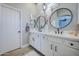 Stylish bathroom with double vanity, elegant mirrors, and modern light fixture at 3736 E Cotton Ct, Gilbert, AZ 85234