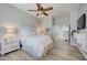 Bright bedroom with wood flooring, ceiling fan, white bed and mirrored nightstand at 3736 E Cotton Ct, Gilbert, AZ 85234