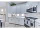 Stylish kitchen featuring white cabinets, marble backsplash, stainless steel appliances, and under-cabinet lighting for a modern feel at 3736 E Cotton Ct, Gilbert, AZ 85234