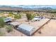 An aerial view of a desert property with horse pens, outbuildings and other desert homes in the distance at 37508 N 12Th St, Phoenix, AZ 85086