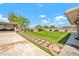 Spacious backyard with lush artificial turf, mature trees, and a charming stone pathway, ideal for outdoor enjoyment at 37508 N 12Th St, Phoenix, AZ 85086