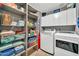 Well-organized laundry room with modern washer, dryer, storage shelves and white cabinetry at 37508 N 12Th St, Phoenix, AZ 85086