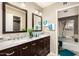 Bathroom featuring double sinks, a large mirror, and tiled shower-tub at 4033 E Larkspur Dr, Phoenix, AZ 85032