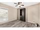 Neutral bedroom with built-in shelving, ceiling fan, wood-look floors, and bright window at 4033 E Larkspur Dr, Phoenix, AZ 85032