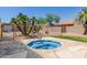 A community hot tub with stone trim offers a relaxing oasis surrounded by lush landscaping and desert foliage at 4033 E Larkspur Dr, Phoenix, AZ 85032