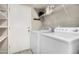 Bright laundry room with a white washer and dryer and built in shelving at 4033 E Larkspur Dr, Phoenix, AZ 85032