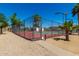 Fenced-in community tennis court is surrounded by desert landscaping, providing a secure and enjoyable playing environment at 4033 E Larkspur Dr, Phoenix, AZ 85032