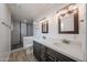 This bathroom features dual sinks, modern lighting fixtures, and a luxurious walk-in shower at 4102 W Maryland Ave, Phoenix, AZ 85019