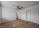 This bedroom features wood-look floors, a modern ceiling fan, and a closet with sliding doors at 4102 W Maryland Ave, Phoenix, AZ 85019