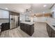 View of kitchen with stainless steel refrigerator and open floor plan into living space at 4102 W Maryland Ave, Phoenix, AZ 85019
