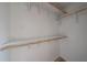 This walk-in closet offers wood rods and a shelf for practical storage at 4102 W Maryland Ave, Phoenix, AZ 85019