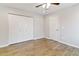 This bedroom features wood floors, a ceiling fan, and a closet with bifold doors at 4107 E Fairview Cir, Mesa, AZ 85206