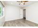 Cozy bedroom features wood-look flooring, natural light, and a ceiling fan at 4107 E Fairview Cir, Mesa, AZ 85206