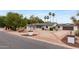 Classic single-story home with circular driveway, manicured landscaping, and mature palm trees at 4107 E Fairview Cir, Mesa, AZ 85206