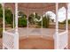 Inside the gazebo, showcasing a tiled floor and white lattice details with views of desert landscaping at 4107 E Fairview Cir, Mesa, AZ 85206