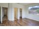Bright bedroom features wood floors, large window with views, and two doorways leading to a closet and bathroom at 4141 W Potter Dr, Glendale, AZ 85308