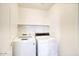 Modern laundry room with white washer and dryer and a shelf for laundry products at 4141 W Potter Dr, Glendale, AZ 85308