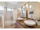 Bathroom featuring double sinks, decorative mirrors, and shower/tub combo at 4448 E Sleepy Ranch Rd, Cave Creek, AZ 85331