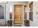 Elegant front door with decorative details and potted flowers creating a welcoming entrance at 4448 E Sleepy Ranch Rd, Cave Creek, AZ 85331