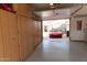 Garage with lots of wood storage cabinets, polished floors, and a red car outside at 4448 E Sleepy Ranch Rd, Cave Creek, AZ 85331