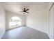 Bright bedroom with gray tiled flooring, ceiling fan, and an arch window providing natural light at 4528 W Butler Dr, Glendale, AZ 85302