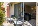 Balcony with outdoor chairs, table, and view into the living area with leather seating at 4630 N 68Th St # 221, Scottsdale, AZ 85251