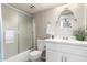 Bathroom with large round mirror over white sink, framed sliding shower doors, and toilet at 4630 N 68Th St # 221, Scottsdale, AZ 85251