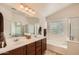 Well-lit bathroom with double sinks, a soaking tub, and a separate shower at 5502 N Ormondo Way, Litchfield Park, AZ 85340
