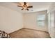A cozy bedroom features neutral walls, a ceiling fan, and a window for natural light at 5502 N Ormondo Way, Litchfield Park, AZ 85340