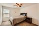 This carpeted bedroom has a ceiling fan, window and a queen sized bed at 5502 N Ormondo Way, Litchfield Park, AZ 85340