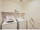 Bright laundry room with white washer, dryer, and an overhead shelf at 5502 N Ormondo Way, Litchfield Park, AZ 85340