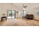 Living room featuring plush carpeting, a ceiling fan, and a sliding glass door to the backyard at 5502 N Ormondo Way, Litchfield Park, AZ 85340