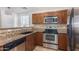 Well-lit kitchen featuring stainless steel appliances, granite countertops, and wood cabinets at 5757 S 21St Ter, Phoenix, AZ 85040