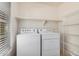 This laundry room features a newer washer and dryer with shelving for storage at 5757 S 21St Ter, Phoenix, AZ 85040