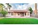 Inviting backyard with artificial turf, covered patio, mature trees, and a well-manicured landscape at 5941 W Venus Way, Chandler, AZ 85226