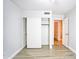 A minimalist bedroom with a closet, hardwood floors, and a doorway to the bathroom at 5941 W Venus Way, Chandler, AZ 85226