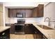 Features a modern stainless steel range and microwave, gorgeous countertops, and sleek cabinets at 5941 W Venus Way, Chandler, AZ 85226