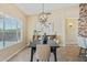 Bright dining room featuring a modern chandelier, decorative wall art, and a view to the outdoors at 616 E Lavitt Ln, Phoenix, AZ 85086