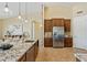 Gourmet kitchen features an island with marble countertops, stainless appliances, and ample cabinet space at 616 E Lavitt Ln, Phoenix, AZ 85086