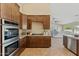 Gourmet kitchen showcasing stainless appliances, gas range, and ample dark wood cabinets at 616 E Lavitt Ln, Phoenix, AZ 85086