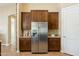 Kitchen with stainless steel refrigerator and dark cabinets, plus stone accent wall at 616 E Lavitt Ln, Phoenix, AZ 85086