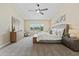 Spacious main bedroom with a ceiling fan, dresser, nightstand, and view to the outdoors at 616 E Lavitt Ln, Phoenix, AZ 85086