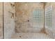 Walk-in shower featuring a decorative glass block window and shower niche at 616 E Lavitt Ln, Phoenix, AZ 85086